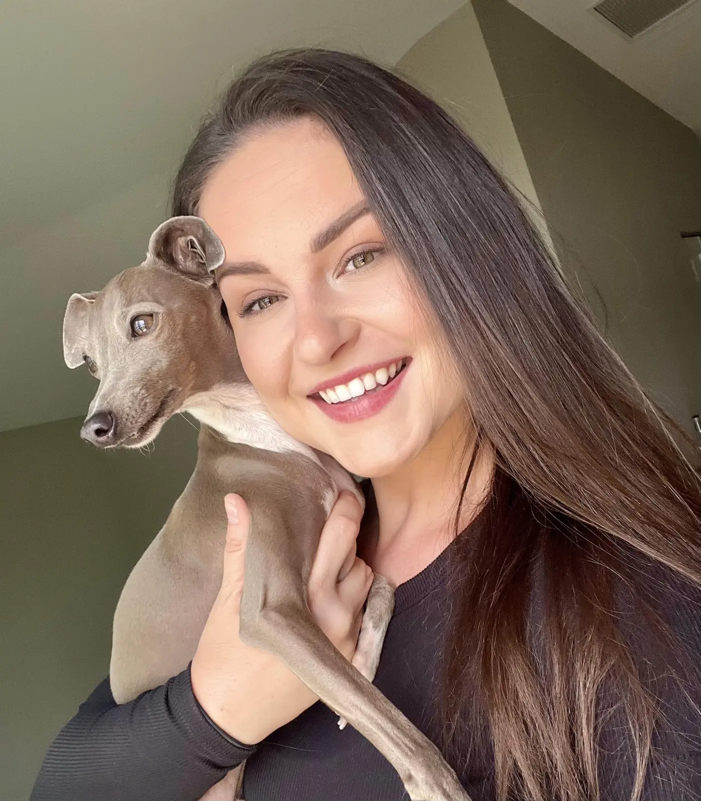 Brittany Mead smiling while holding a dog
